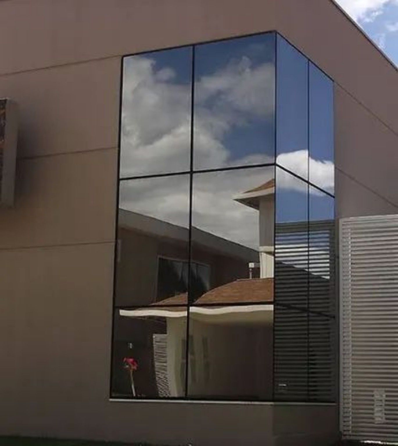Pele de vidro com grandes painéis envidraçados, perfis de alumínio e ferragens/componentes de fixação.
